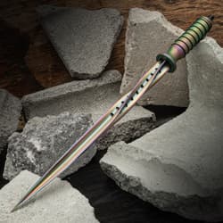 Rainbow Titanium Spiral Dagger laying on busted cinder blocks.